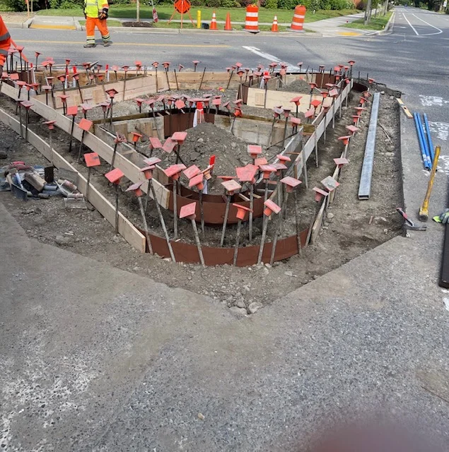 Concrete curb and gutter installation with steel forms and wooden bracing on residential street